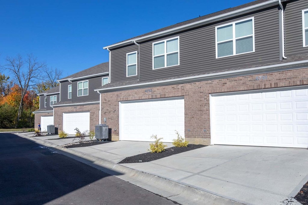a brick house with two garage doors in front of it