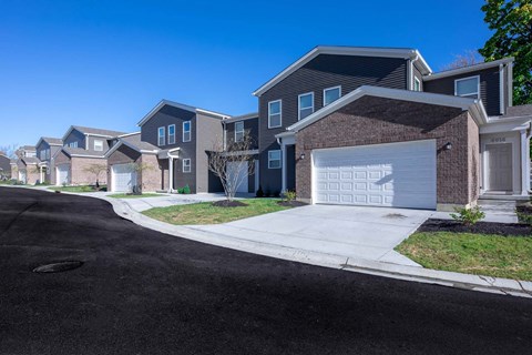 a sidewalk in front of a row of houses