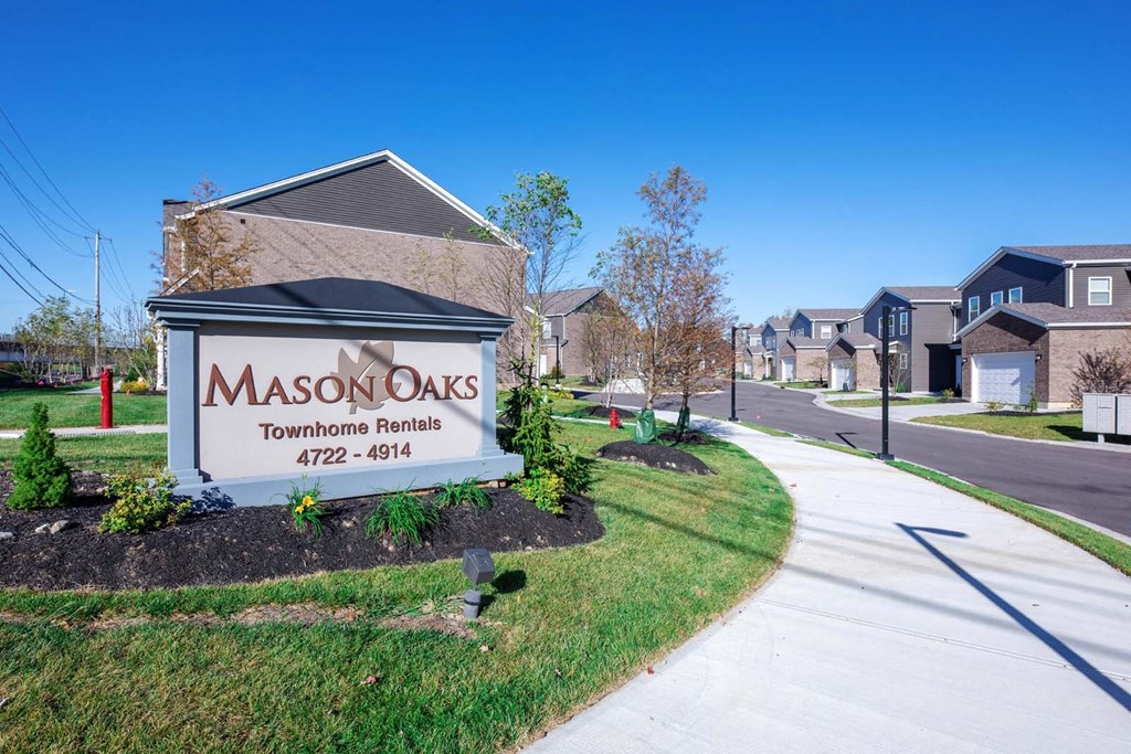 a community sign townhomes in front of a street