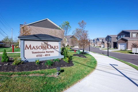 a community sign townhomes in front of a street