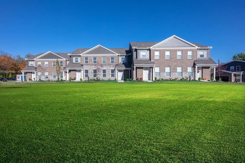 a large green lawn in front of a large house