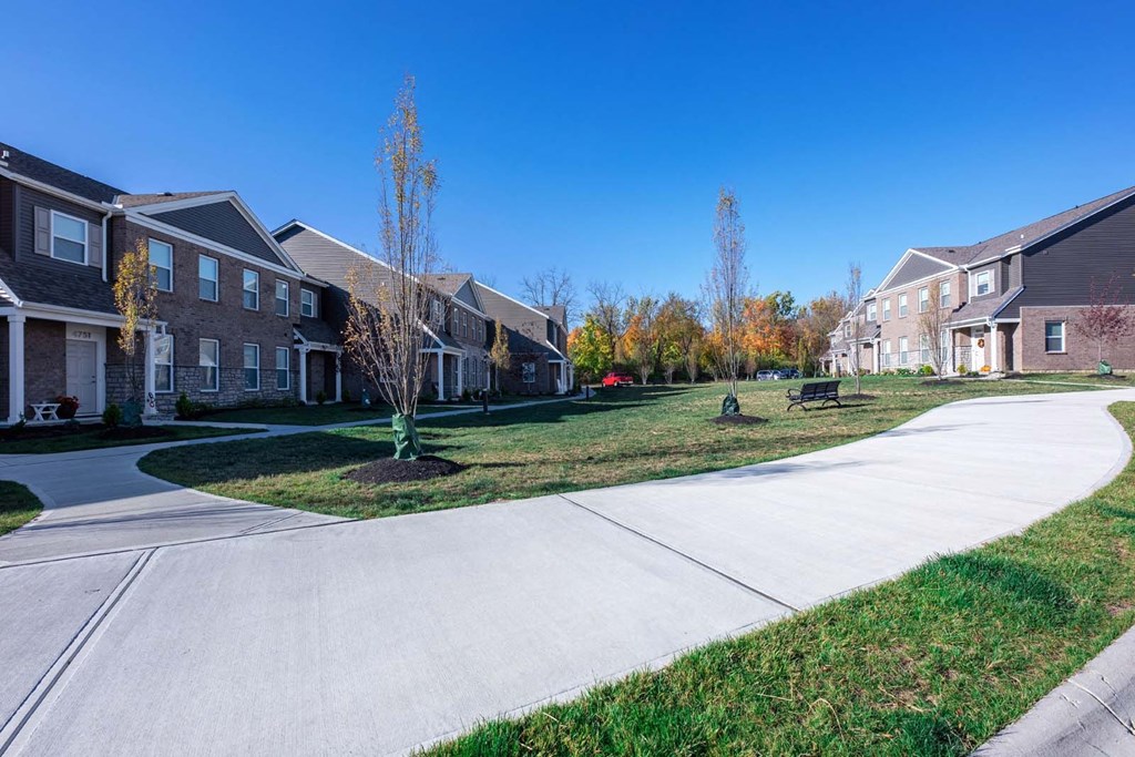 a sidewalk in front of a row of houses