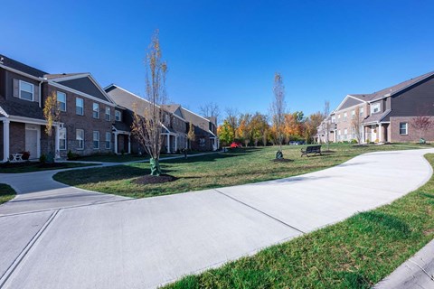 a sidewalk in front of a row of houses