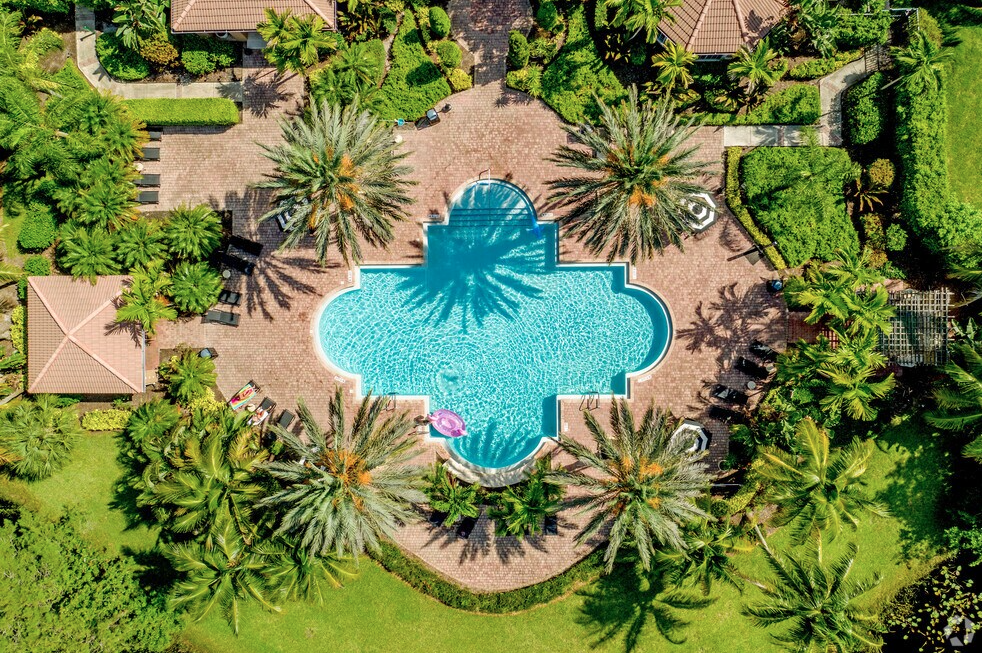 A large blue pool surrounded by palm trees.