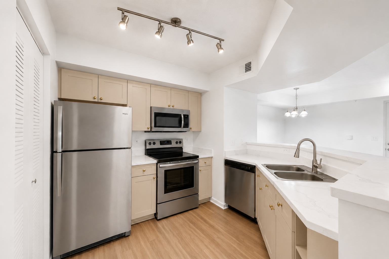 A modern kitchen with stainless steel appliances and wooden floors.