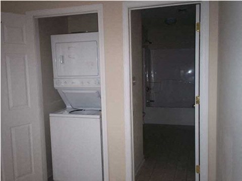 A white microwave oven is built into a cabinet in a room.