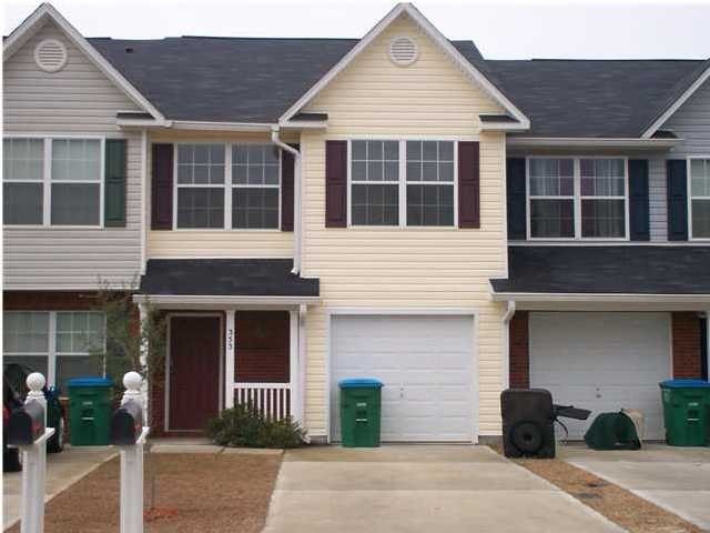 A two-story house with a garage and a driveway.