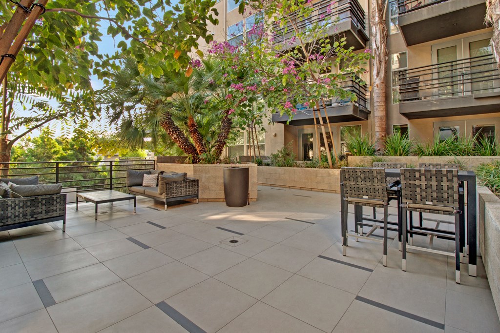an outdoor patio with tables and chairs and trees