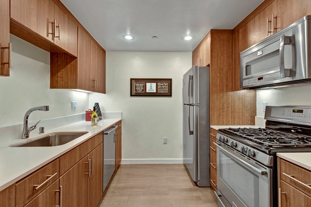 a kitchen with stainless steel appliances and wooden cabinets