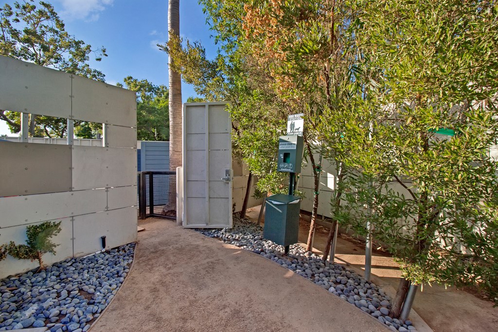 the entrance to the house has a gravel path and trees