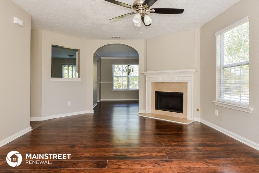 the living room of an empty house with a fireplace