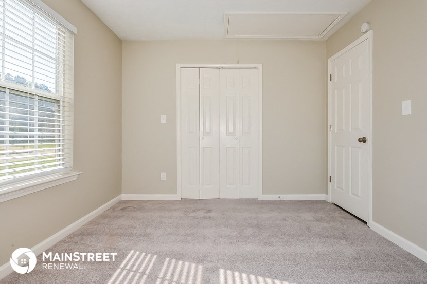 a bedroom with a carpeted floor and a white door