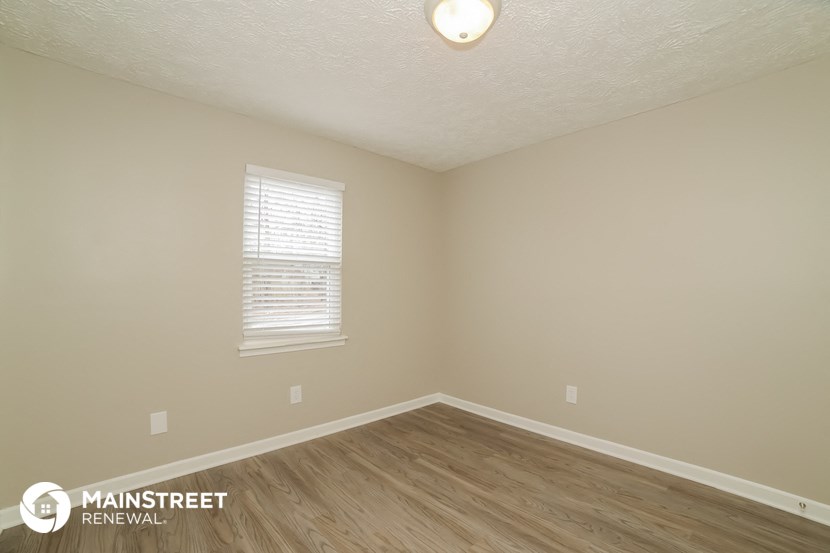 the interior of an empty room with wooden floors and a window