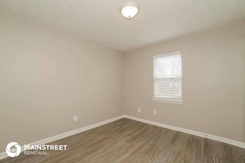 the interior of an empty room with wooden floors and a window