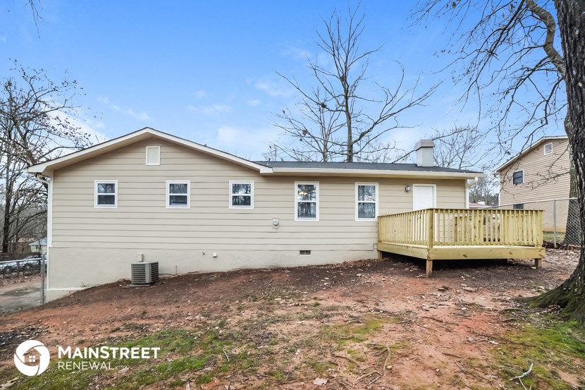 the back of a house with a deck and a fence