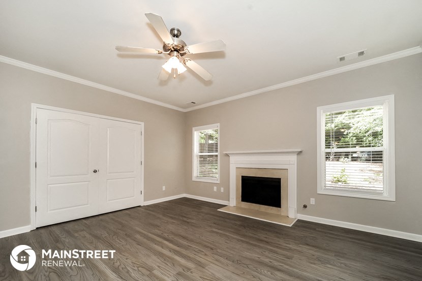 the living room with fireplace and ceiling fan