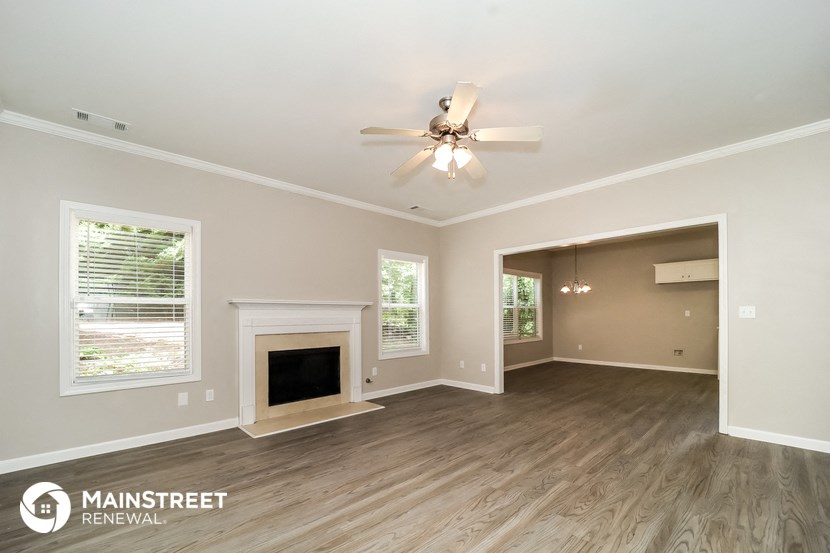 the living room with fireplace and ceiling fan