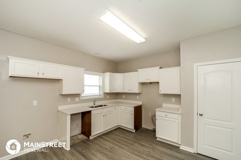 a kitchen with white cabinets and white counter tops and a sink