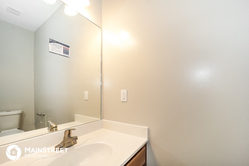 a bathroom with a mirror and a sink and a toilet