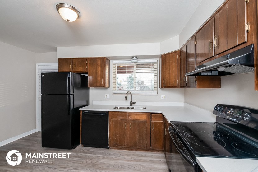 a kitchen with black appliances and wooden cabinets
