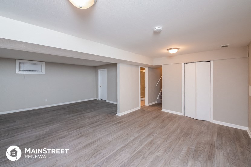 an empty living room with white walls and wood flooring