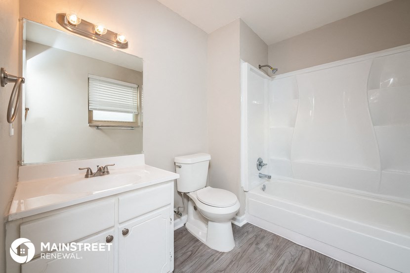 a white bathroom with a toilet and a tub and a sink