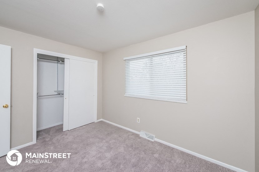 a bedroom with a closet and a door to the bathroom