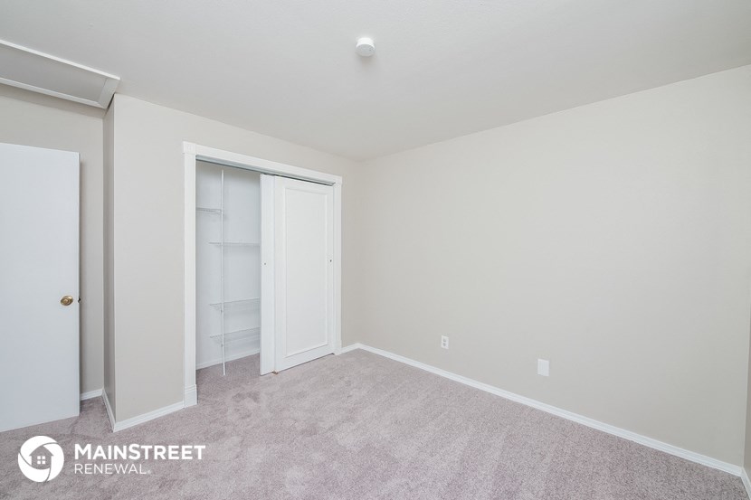 a bedroom with a closet and a carpeted floor