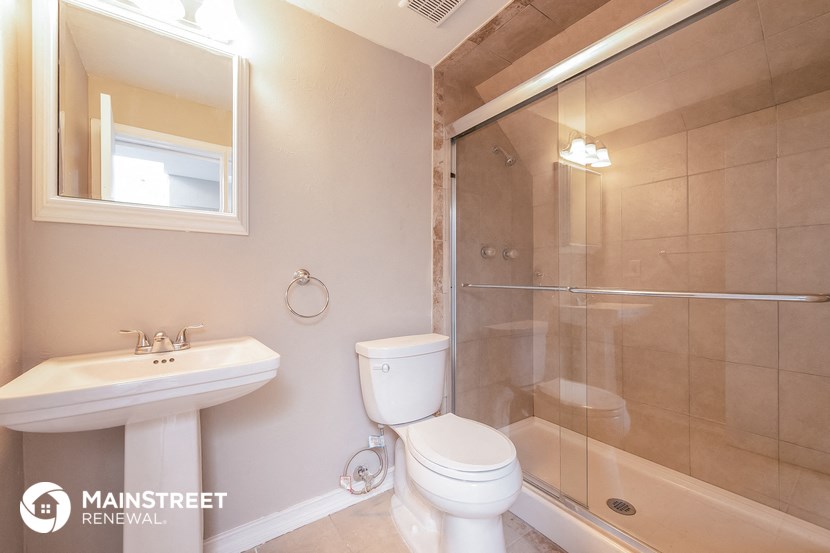a white bathroom with a shower toilet and sink