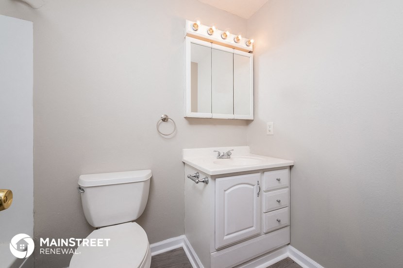 a bathroom with a toilet and a sink and a mirror
