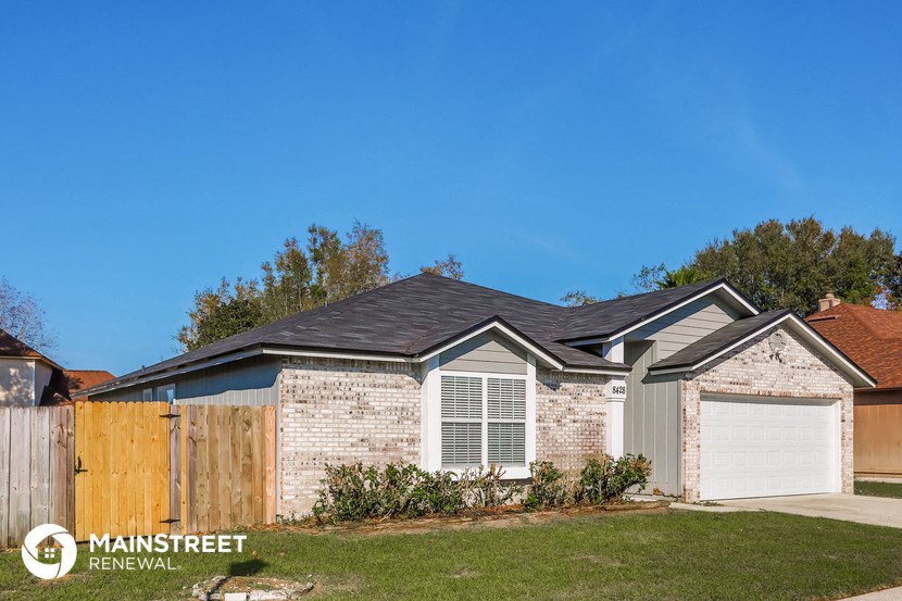 a brick house with a wooden fence and a yard