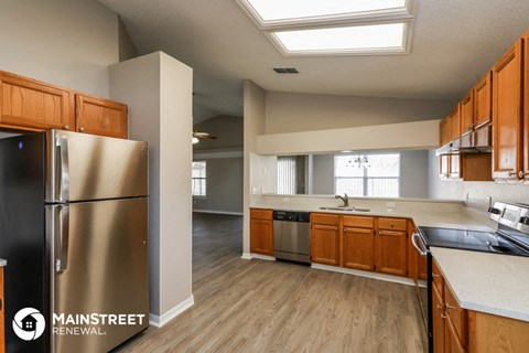 a kitchen with wooden cabinets and a stainless steel refrigerator