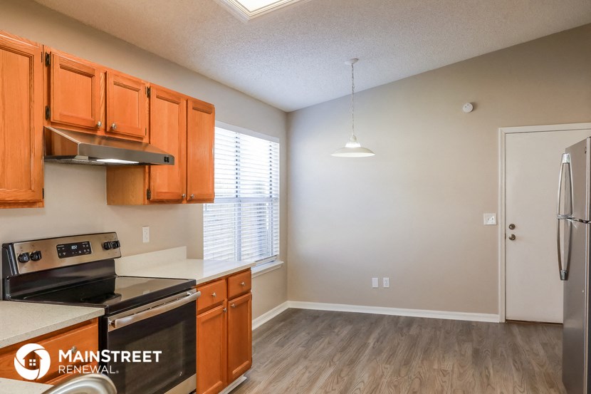 a kitchen with wooden cabinets and a stove and a refrigerator