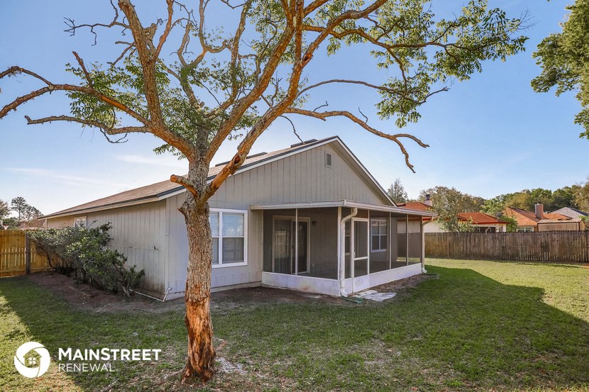the front of a house with a tree in the yard
