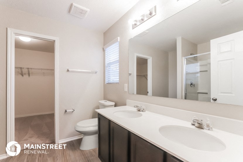 a bathroom with two sinks and a mirror and a toilet