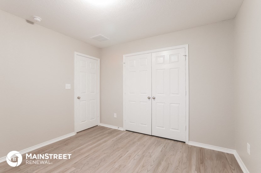 the upstairs bedroom with two closets and a hardwood floor