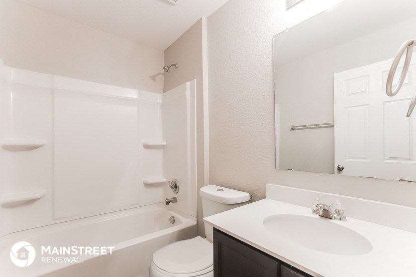 a bathroom with a sink toilet and shower and a mirror