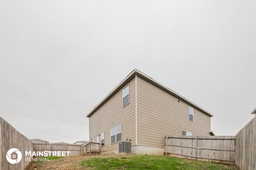the outside of a house with a fence and grass