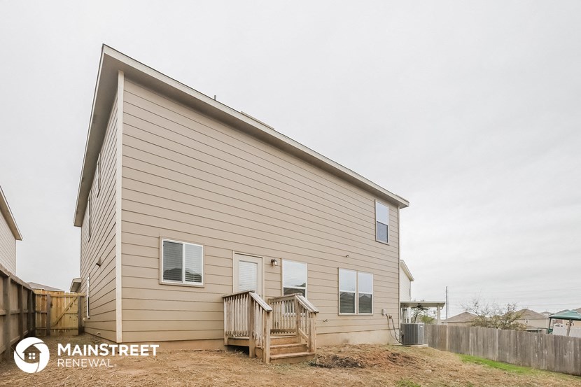 the outside of a house with a backyard and a deck