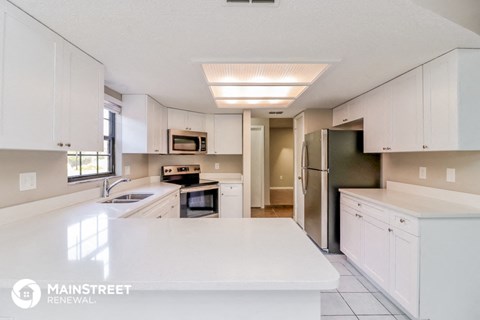 a large kitchen with white cabinets and white counter tops