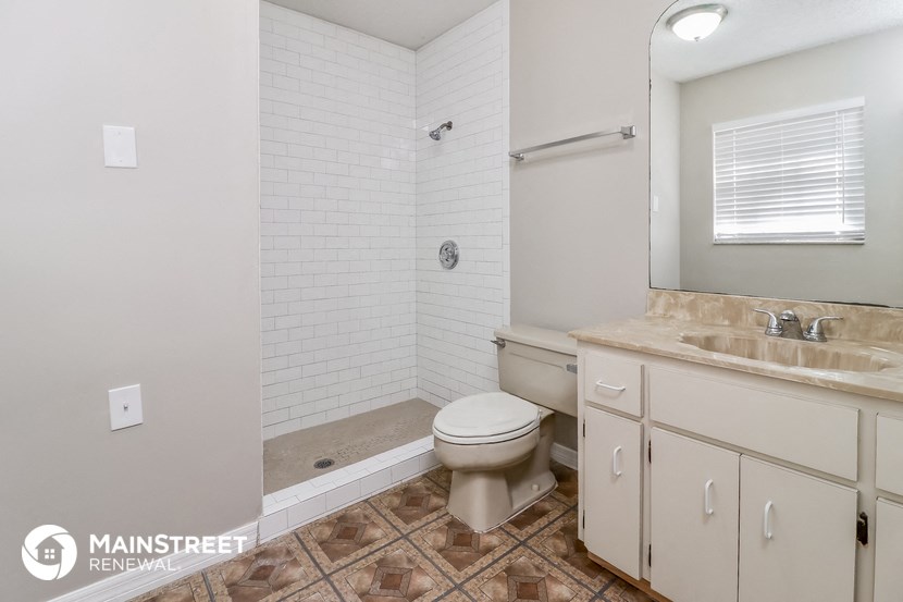 a bathroom with a toilet and a sink and a shower