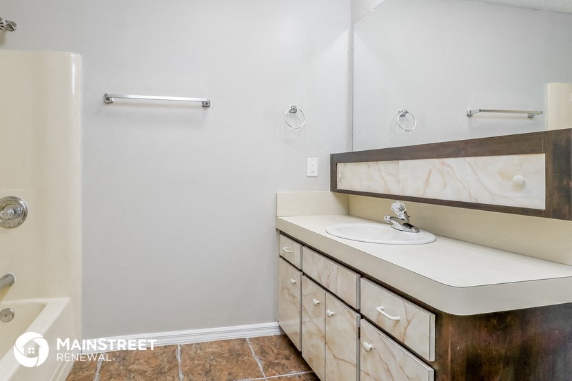 a bathroom with a sink and a mirror and a tub