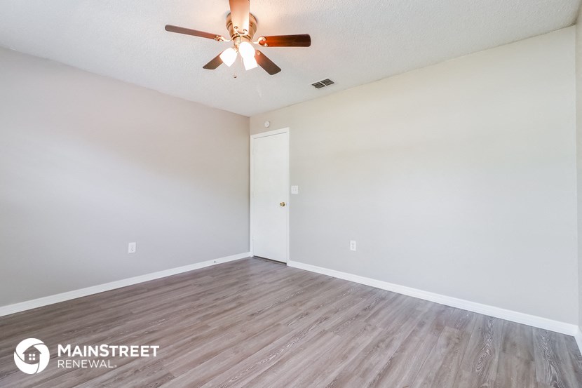 the living room of an empty house with a ceiling fan