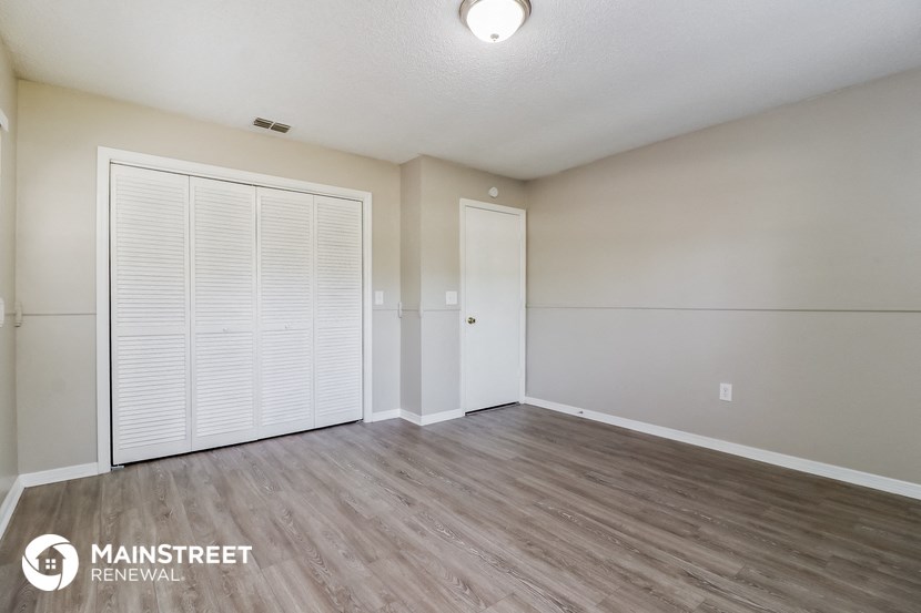 the living room and dining room of an apartment with wood flooring