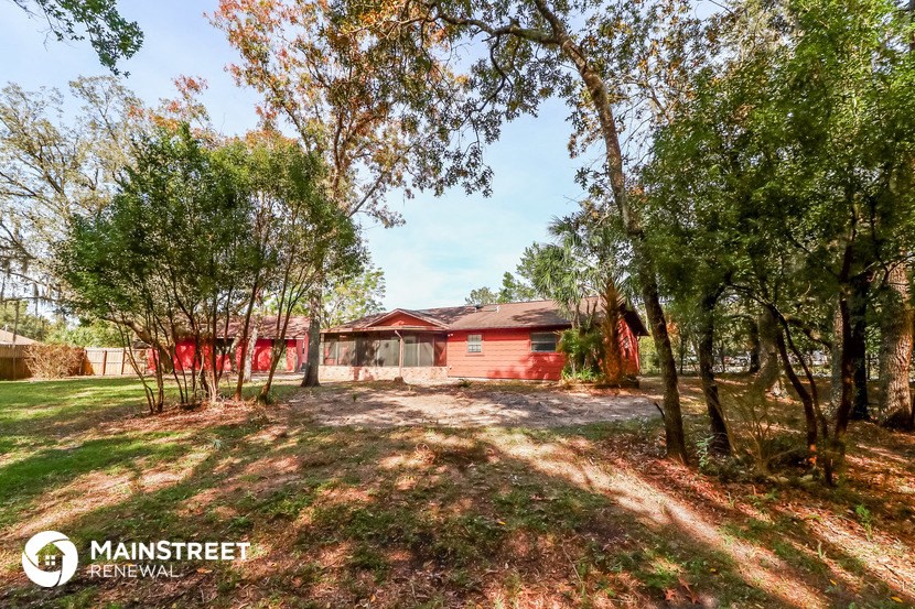 a red house with a yard and trees