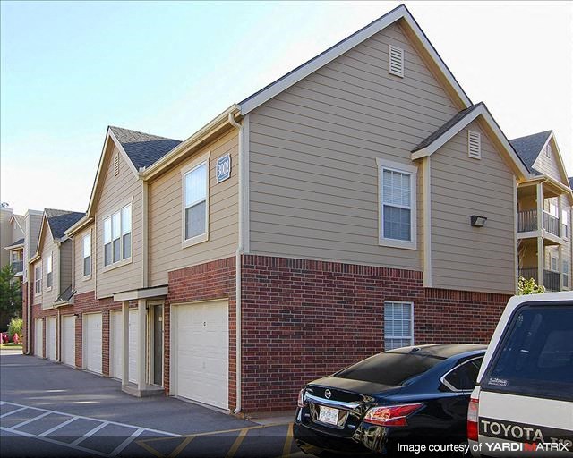 a row of houses with cars parked in a parking lot