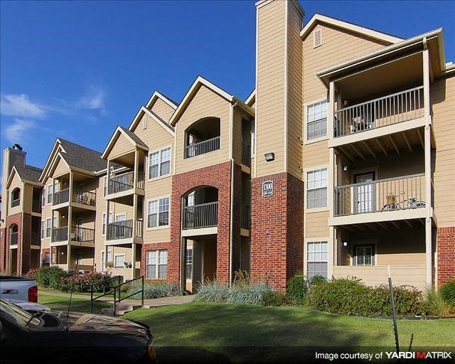 an apartment building with balconies and a lawn