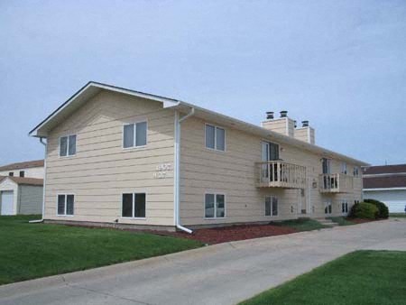 a white house with a balcony and a driveway