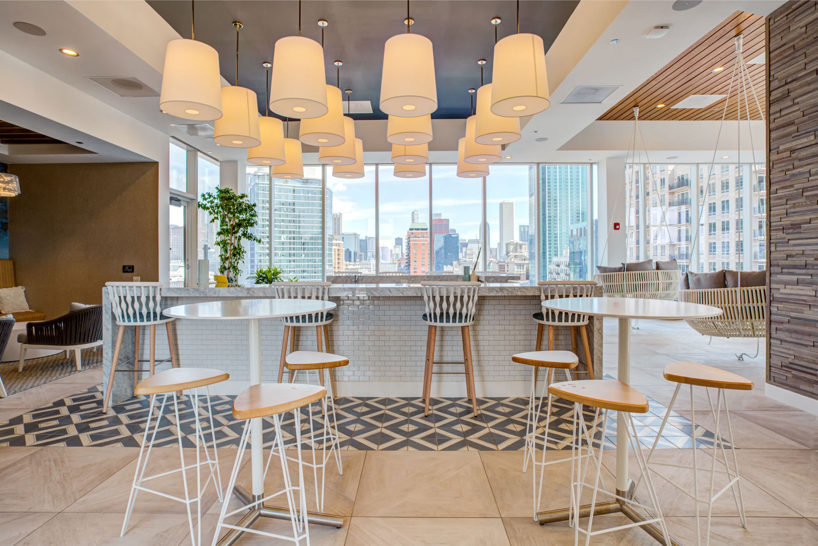 Indoor lounge with high top seating overlooking city views at Eleven40, Chicago, IL, 60605