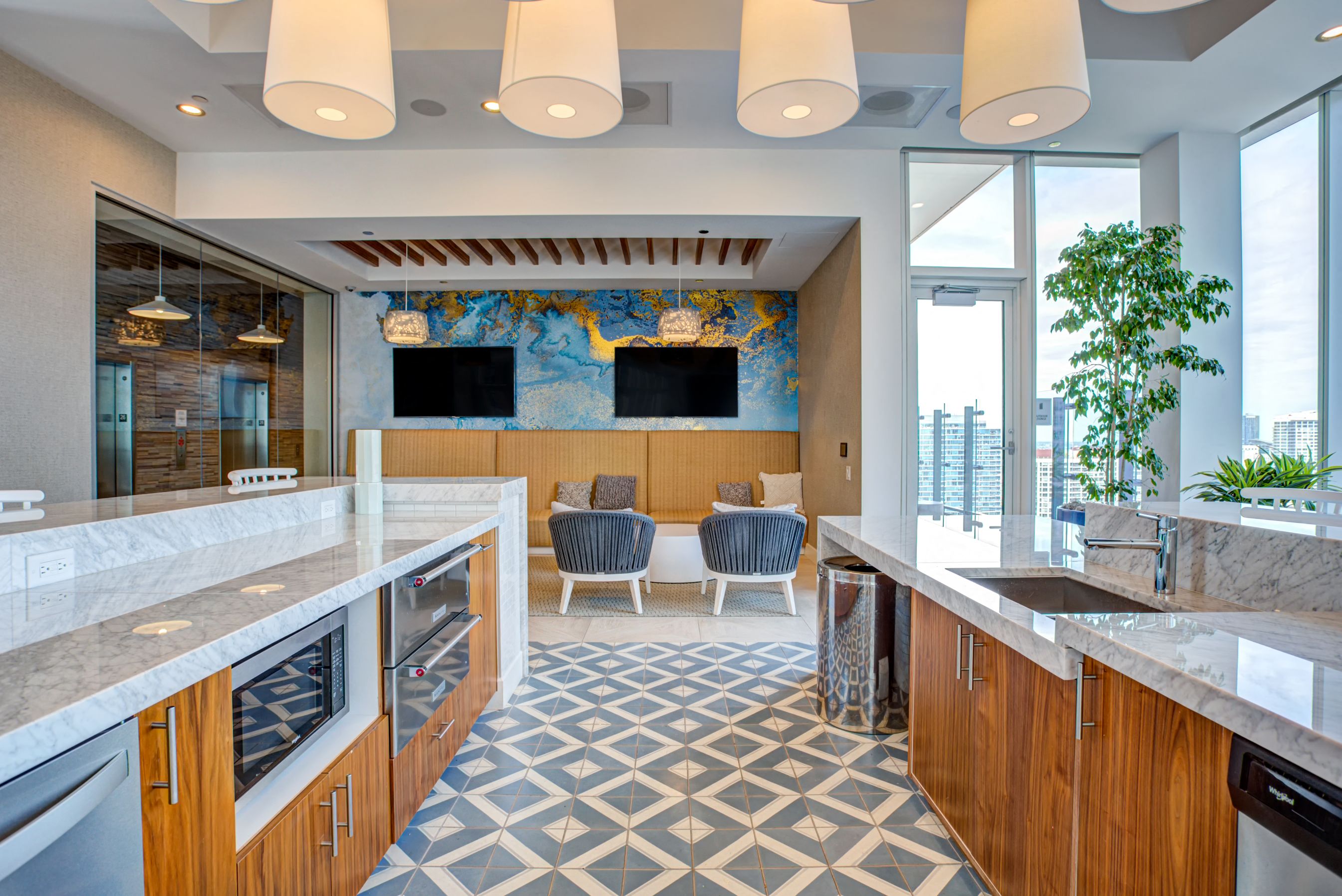 Demonstration kitchen overlooking lounge area with chairs and TVs at Eleven40, Chicago, IL